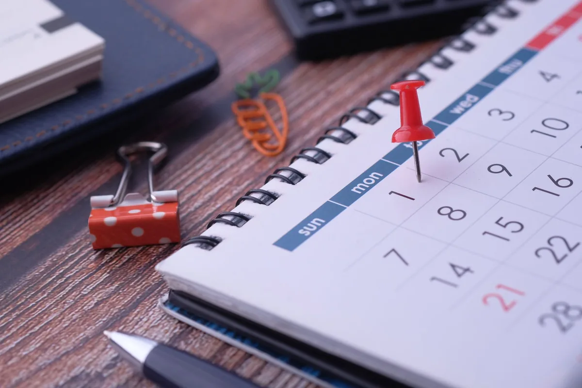A wall calendar with dates marked in red