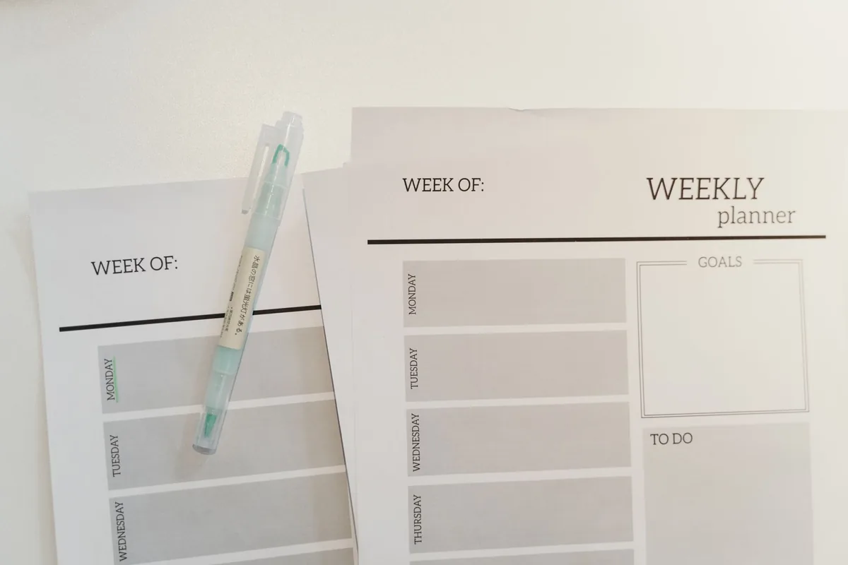 A blank weekly planner sheet with a pen
