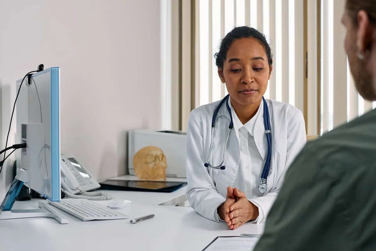 A doctor reviewing notes on a screen with a patient
