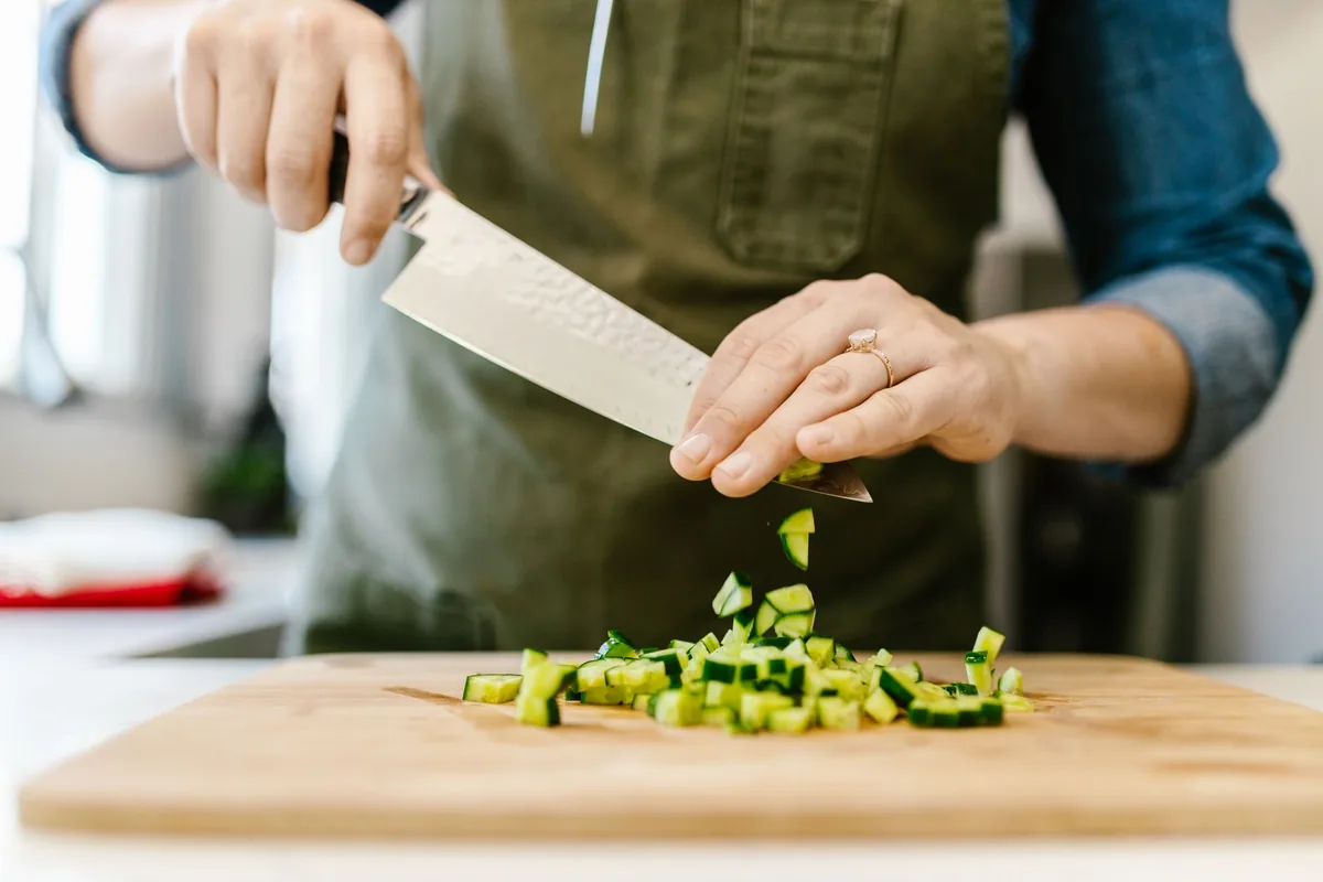 Chopping fresh vegetables on a board at home
